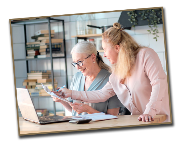 Mother and adult child checking documents in front of laptop.