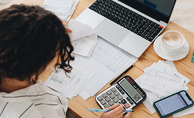 Woman at desk crunching numbers on a calculator